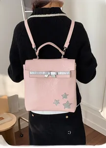 Rear view of a light pink backpack featuring silver stars and bow detail on model