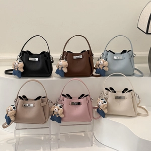 Chic bucket bags in multiple colors with cute teddy bear pendants on tiered display