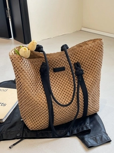 Beige woven straw tote bag with black rope handles and tulips for beach vacation style