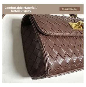 Dettaglio della trama in pelle marrone intrecciata e chiusura metallica dorata della borsa