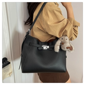 Detail of black pebbled leather hobo bag with silver twist lock and plush bunny charm