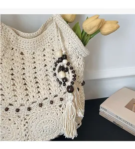 Gros plan du sac fourre-tout tissé ivoire avec perles en bois et décoration à franges