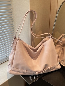 Large nude pink matte leather tote bag with silver hardware on a soft indoor background