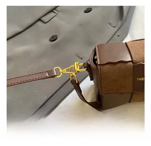 Detail of high-quality gold metal swivel hook on a brown leather crossbody bag