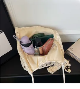 Intérieur spacieux d'un sac à bandoulière au crochet beige avec des objets du quotidien