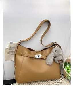 Detailed view of brown lychee grain leather hobo bag with silver twist lock and bunny charm
