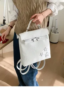 Close-up of a white pleated backpack featuring silver star details and bow buckle