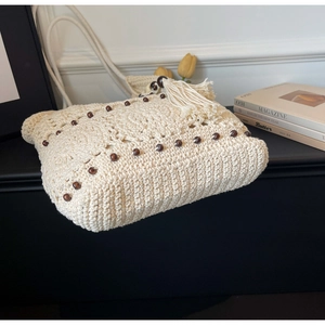 Détails du sac crochet bohème avec perles en bois foncées et un grand gland à franges