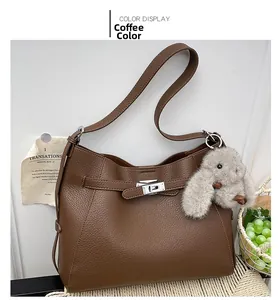 Detail of lychee pattern leather bucket bag with silver turn-lock and rabbit charm