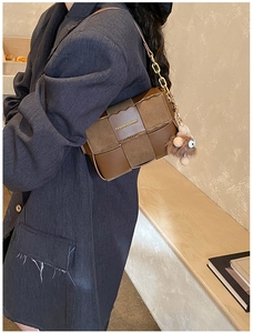 Detail of dark brown checkered crossbody bag with cute plush bear charm and chain strap