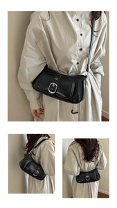 Detail of vintage black leather underarm bag with silver buckle and adjustable shoulder strap