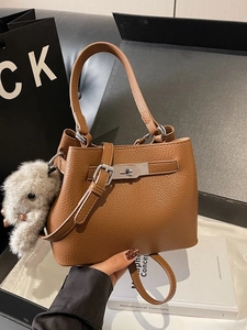 Brown litchi leather bucket bag with silver clasp and plush dog charm handheld style