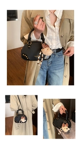 Detail of vintage black bowling bag with gold studs and a cute plush bear charm