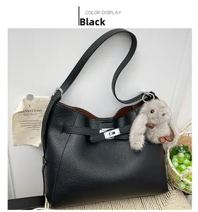 Close-up of black litchi grain leather bag with silver metal twist lock and rabbit charm