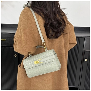 Dettaglio della borsa intrecciata grigio-verde con chiusura a rotazione in metallo dorato