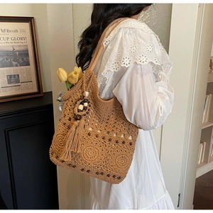 Détail du sac à bandoulière tissé avec motif tournesol au crochet et longs pompons
