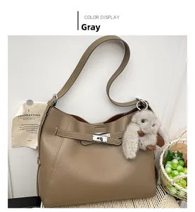 Detail of grey pebbled leather hobo bag with metal buckle and plush bunny charm