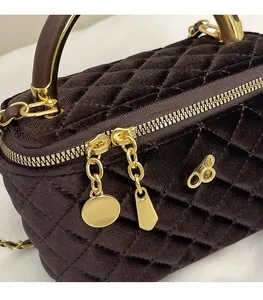 Detail of coffee brown quilted velvet bag featuring gold double zippers and hardware