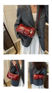 Detail view of deep red oil leather shoulder bag with silver buckle and adjustable strap