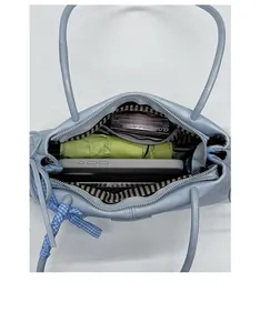 Interior view of light blue leather handbag showing capacity for phone and umbrella