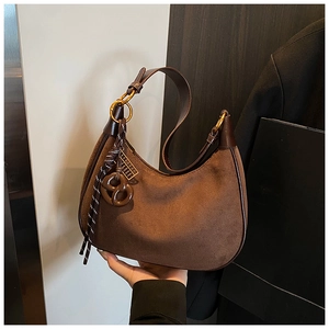 Detailed macro view of vintage brown suede hobo bag with braided rope and golden hardware