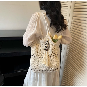 Détail du sac cabas au crochet avec des perles en bois et des pompons élégants