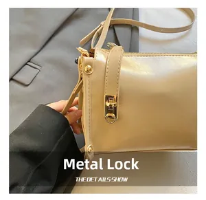 Detailed macro view of the premium golden hardware twist-lock on a beige PU leather handbag