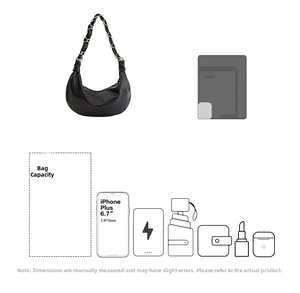 Vue détaillée montrant la grande capacité du sac hobo noir avec des objets du quotidien