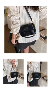 Detail of black woven crossbody bag featuring a golden chain strap and plush bear charm