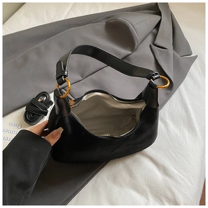 Detail of black hobo bag showing gold ring hardware and herringbone fabric lining