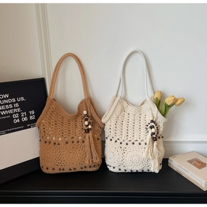 Détail de sacs cabas au crochet faits main avec perles en bois et pompons bohèmes