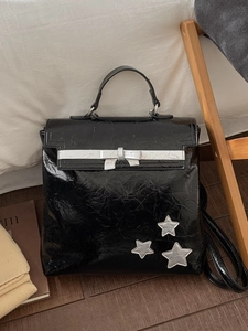 Chic black waxed leather backpack with silver bow ribbon and star charms for travel