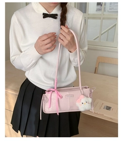 Pink faux leather underarm bag with a checkered bow and plush kitten charm detail
