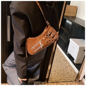 Detailansicht der braunen Punk-Achseltasche mit Metallschnallen und Reißverschlüssen