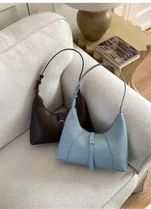 Dettaglio di borse hobo vintage marrone scuro e blu nebbia con motivi in pelle a punto croce