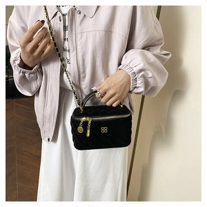 Detail of black velvet quilted mini bag with gold chain strap and clover logo hardware