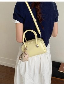 Détail du sac polochon jaune avec charm agneau en peluche et bandoulière réglable