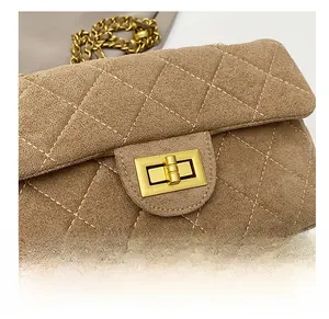 Détail macro du daim kaki matelassé et du fermoir doré sur le sac à bandoulière chic