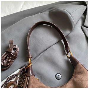 Detail of brown suede patchwork shoulder bag with gold buckles and retro abalone charm