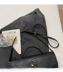 Detail der schwarzen Krokodil-Textur Ledertasche mit goldenem Hasen-Drehverschluss
