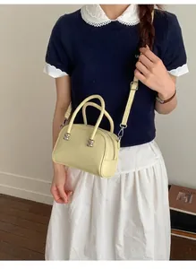 Zitronengelbe Boston-Tasche aus Leder in stilvoller Crossbody-Seitenansicht getragen