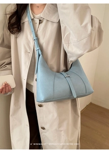 Dettaglio della borsa hobo azzurra con cuciture verticali e fibbia ad anello argento