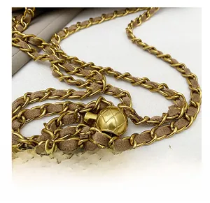 Détail de la bandoulière chaîne dorée avec velours marron et boule de réglage en métal