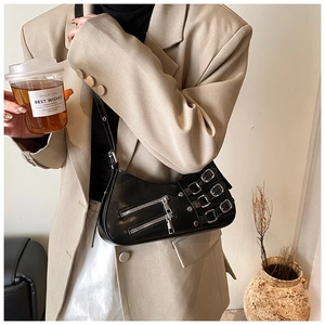 Detail der schwarzen Achseltasche mit silbernen Reißverschlüssen und Riemen am Blazer-Outfit