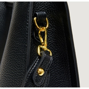 Detail of lychee pattern black leather bag with polished gold-tone metal D-ring buckle