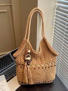 Sac fourre-tout au crochet fait main avec perles en bois et pompon dans un cadre chaleureux