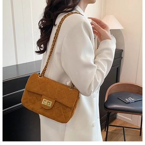 Détail du sac matelassé en daim marron avec bandoulière chaîne dorée et fermoir