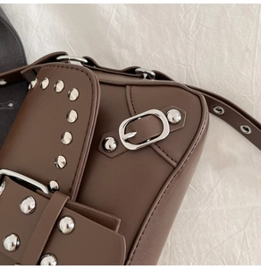 Detailed close-up of dark brown PU leather shoulder bag with silver rivet trim and buckle