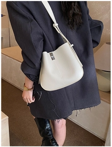Detail of cream white litchi pattern bucket bag with silver metal twist lock closure