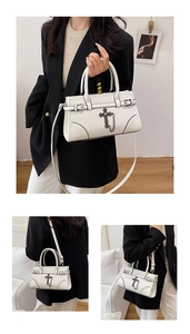 Detail of white woven PU leather handbag with metallic cross charm and chain accents